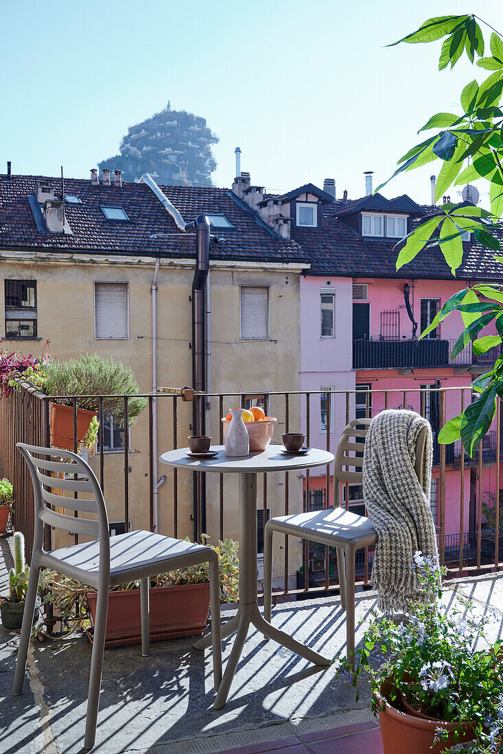 Bistrotisch mit zwei Stühlen auf Balkon, Blick auf Nachbarsgebäude