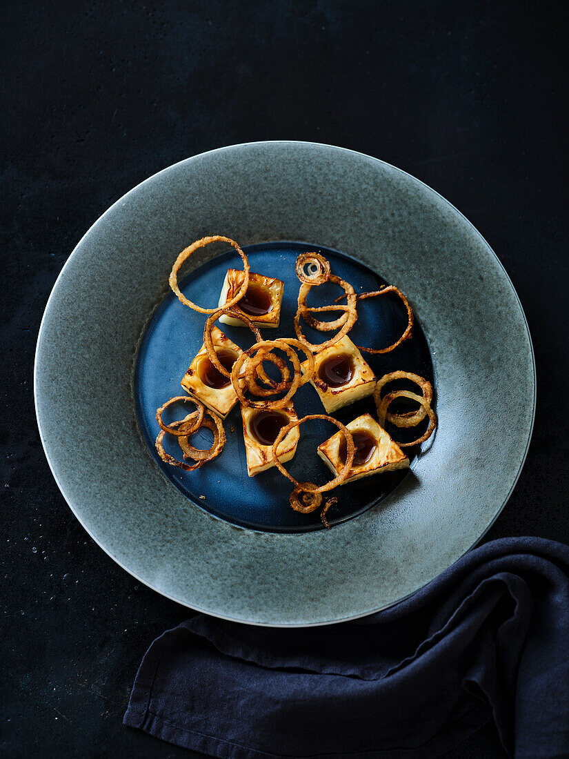 Oven-baked celery with a mushroom reduction and fried onions