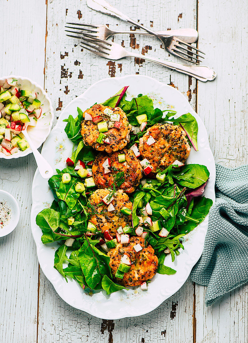 Quinoa and salmon trout patties with cucumber and radish salsa and salad