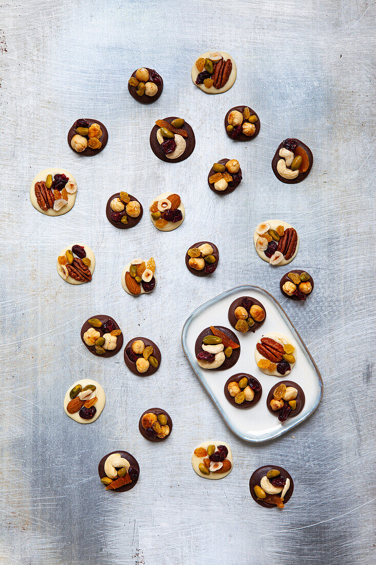 White and dark raw chocolate pralines with nuts and dried fruit