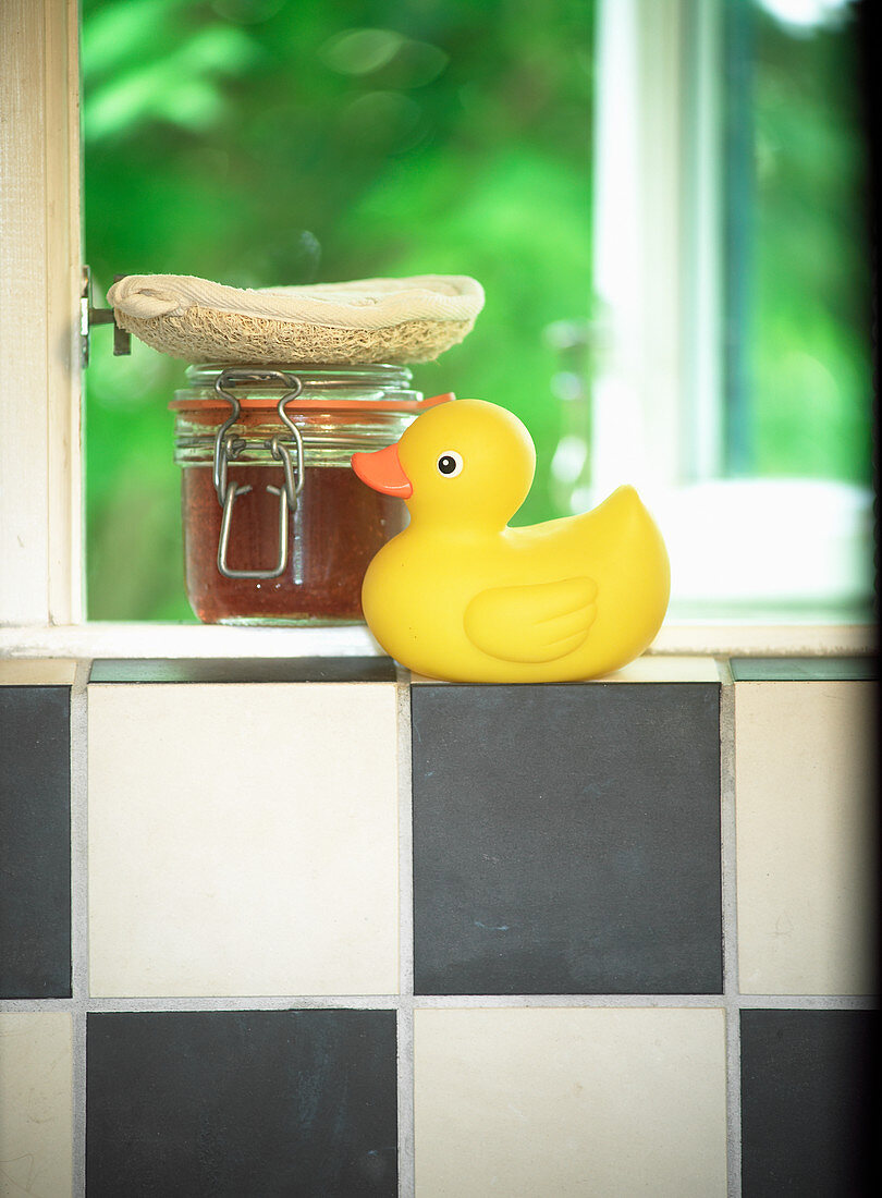 Yellow rubber duck on black and white tiles