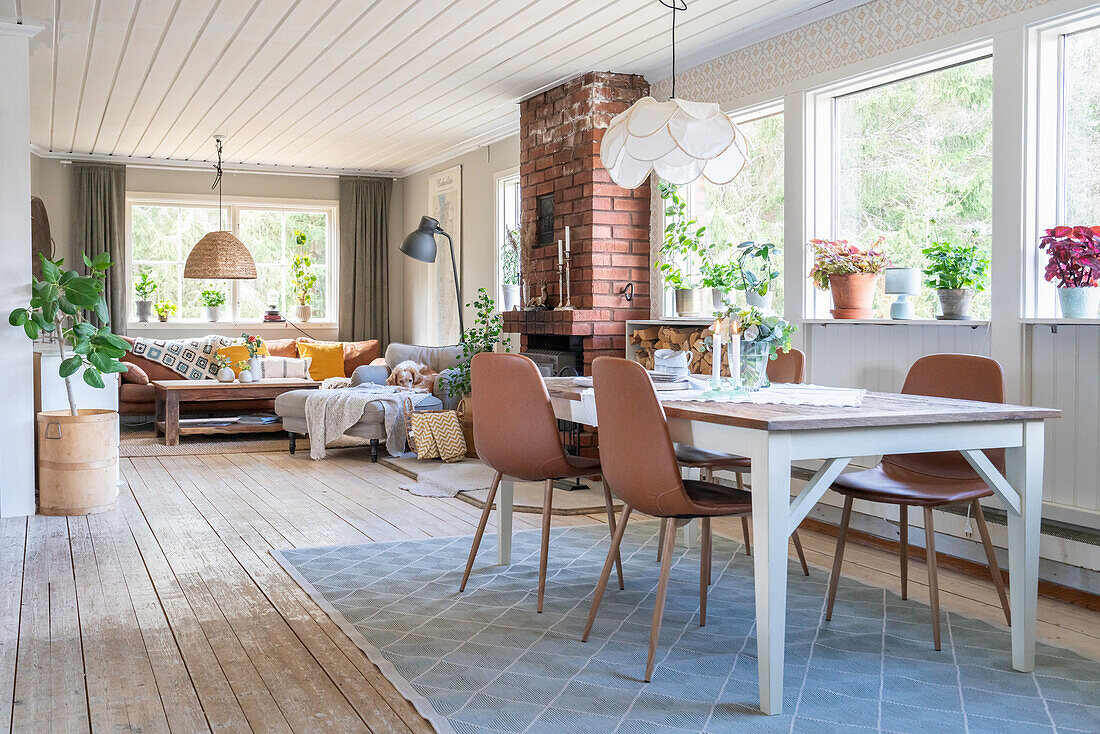 Dining area in front of window in an open plan living room with wooden floorboards