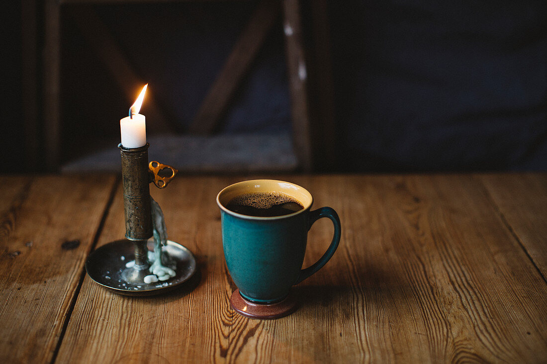 Schwarzer Kaffee und Kerze auf dem Tisch