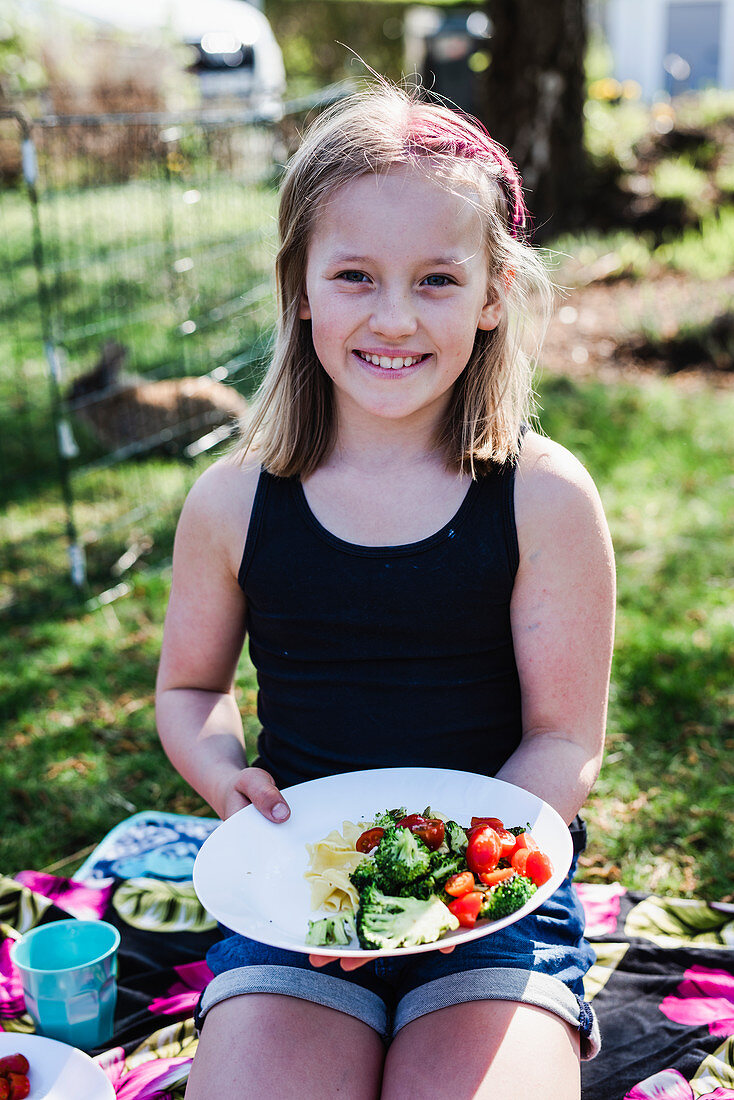 Mädchen beim Picknick mit gefülltem Teller