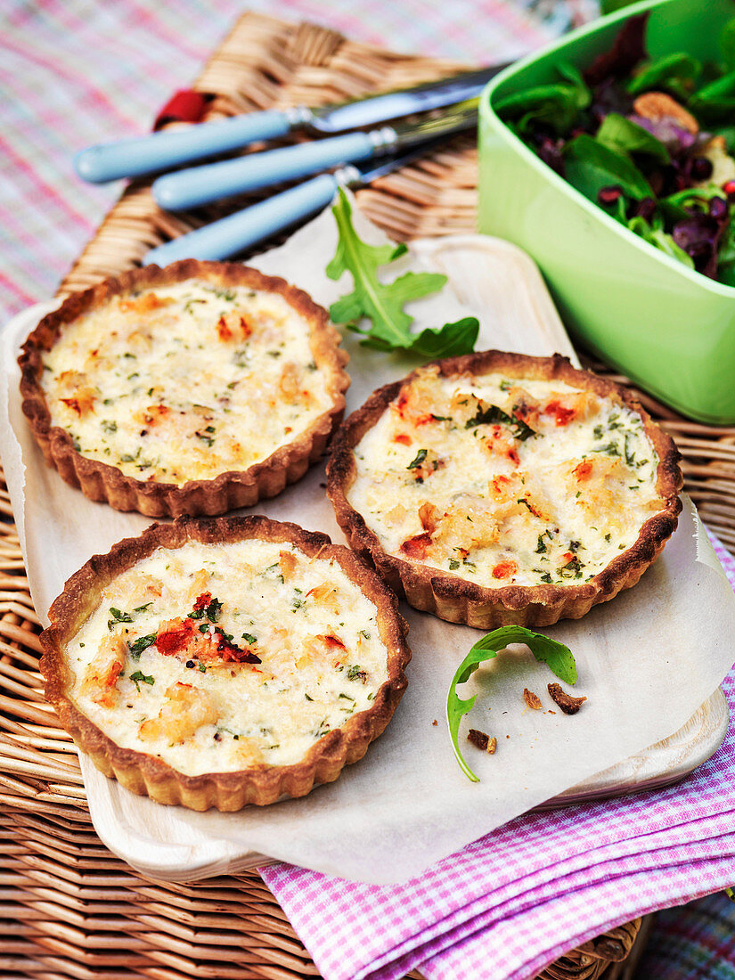 Crab tarts served with salad on a picnic basket
