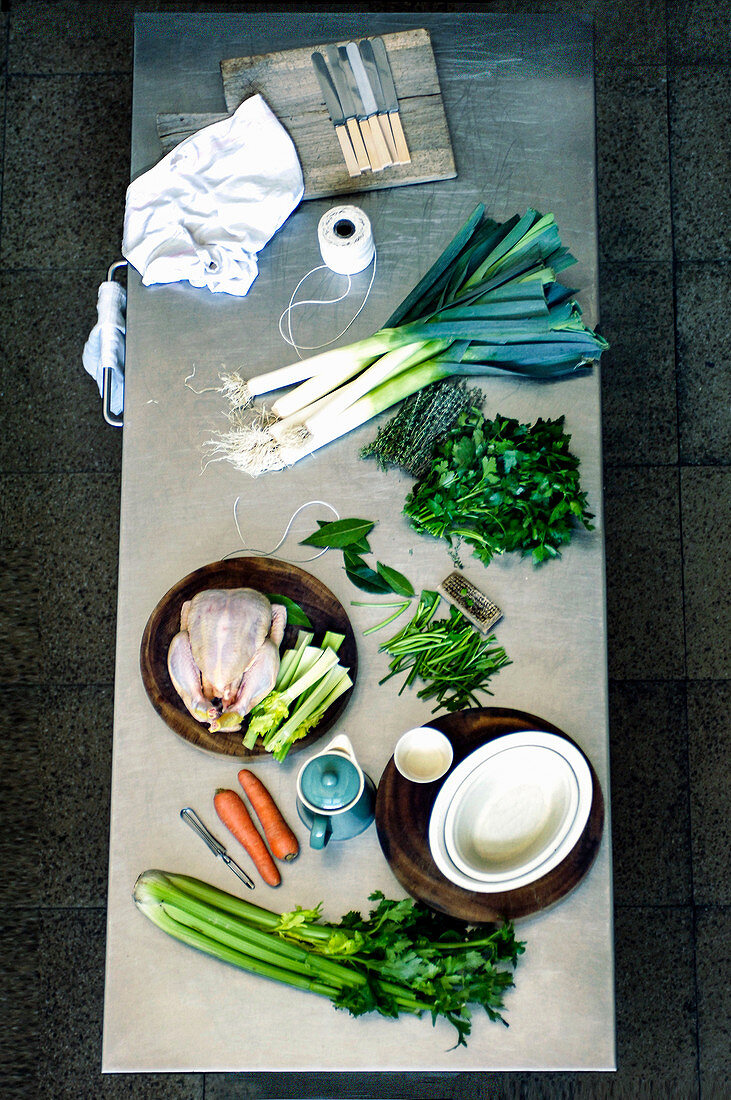 Lauch, Karotten, Sellerie, Kräuter und Huhn als Zutaten für Kasserole auf Küchentisch
