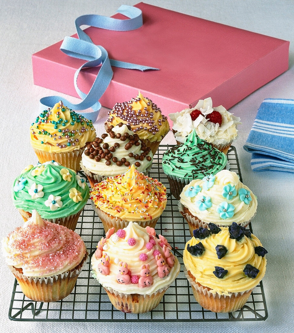 Cupcakes mit verschiedenen Toppings auf Kuchengitter