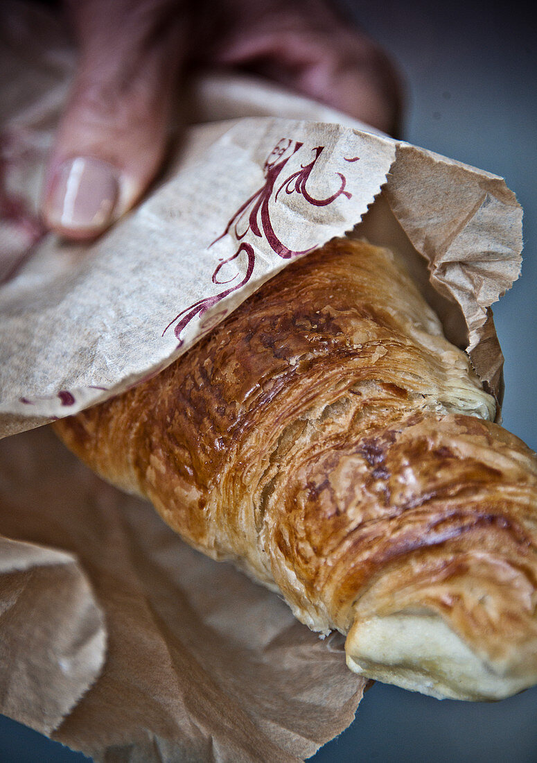 Frisch gebackenes Croissant in Papiertüte