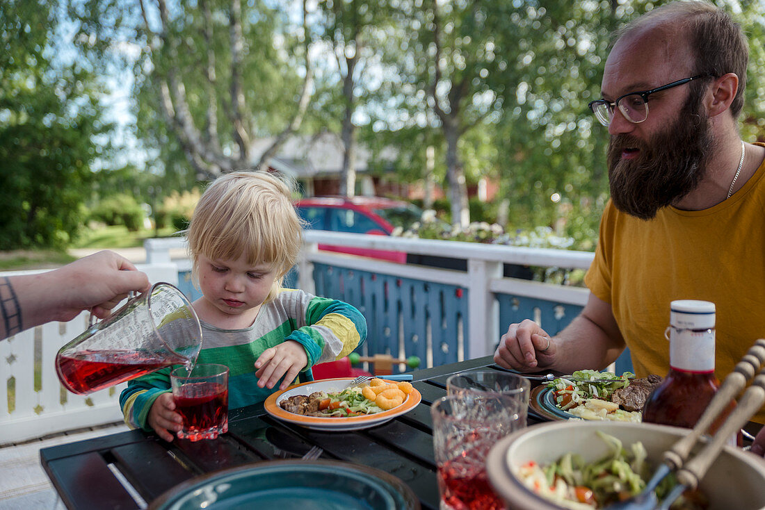 Kleines Mädchen und Vater sitzen am Tisch beim Essen
