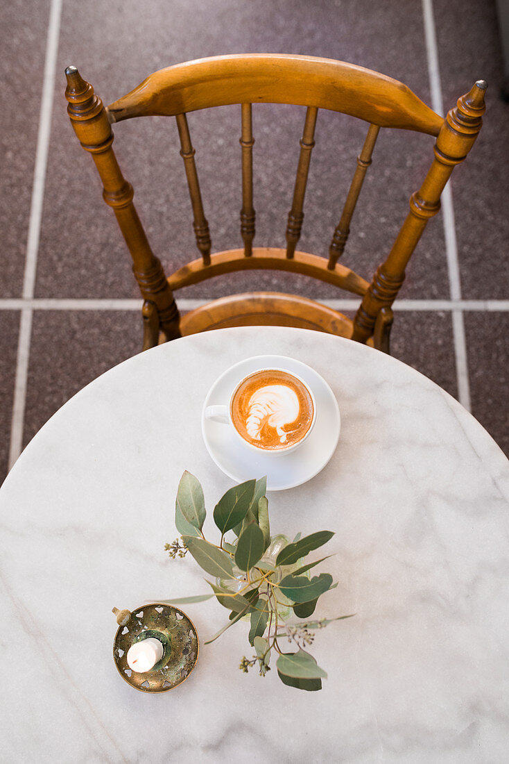 Cappuccino auf Bistrotisch im Café