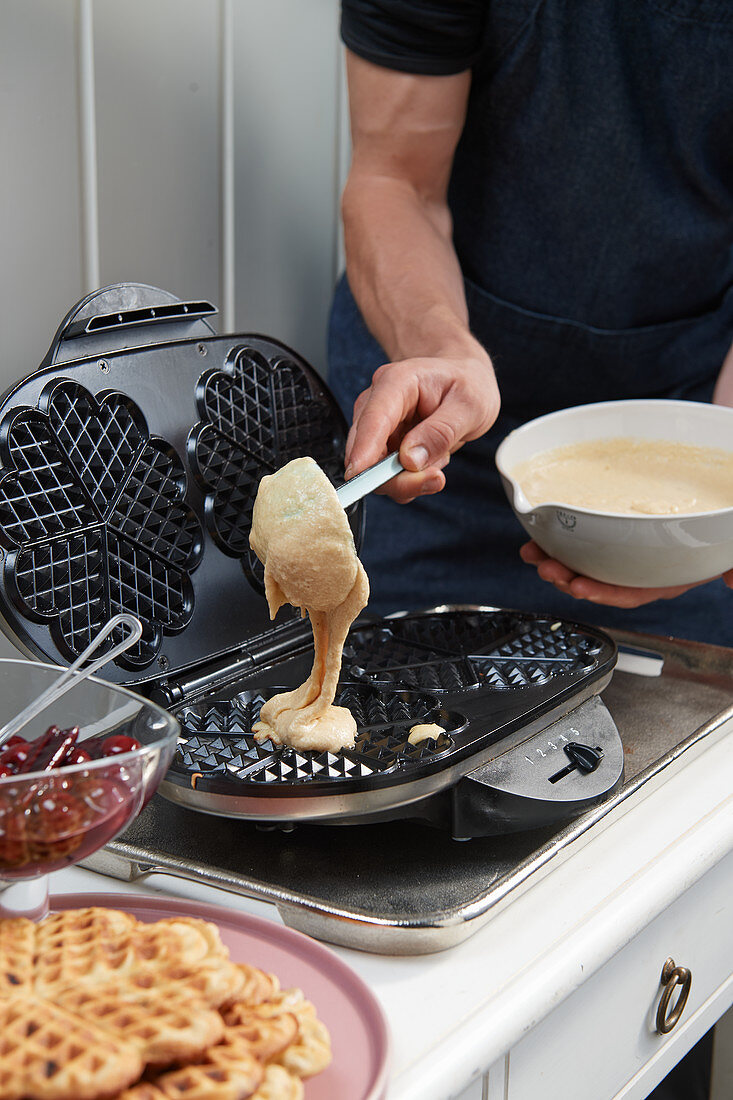 Pouring waffle batter into a waffle iron