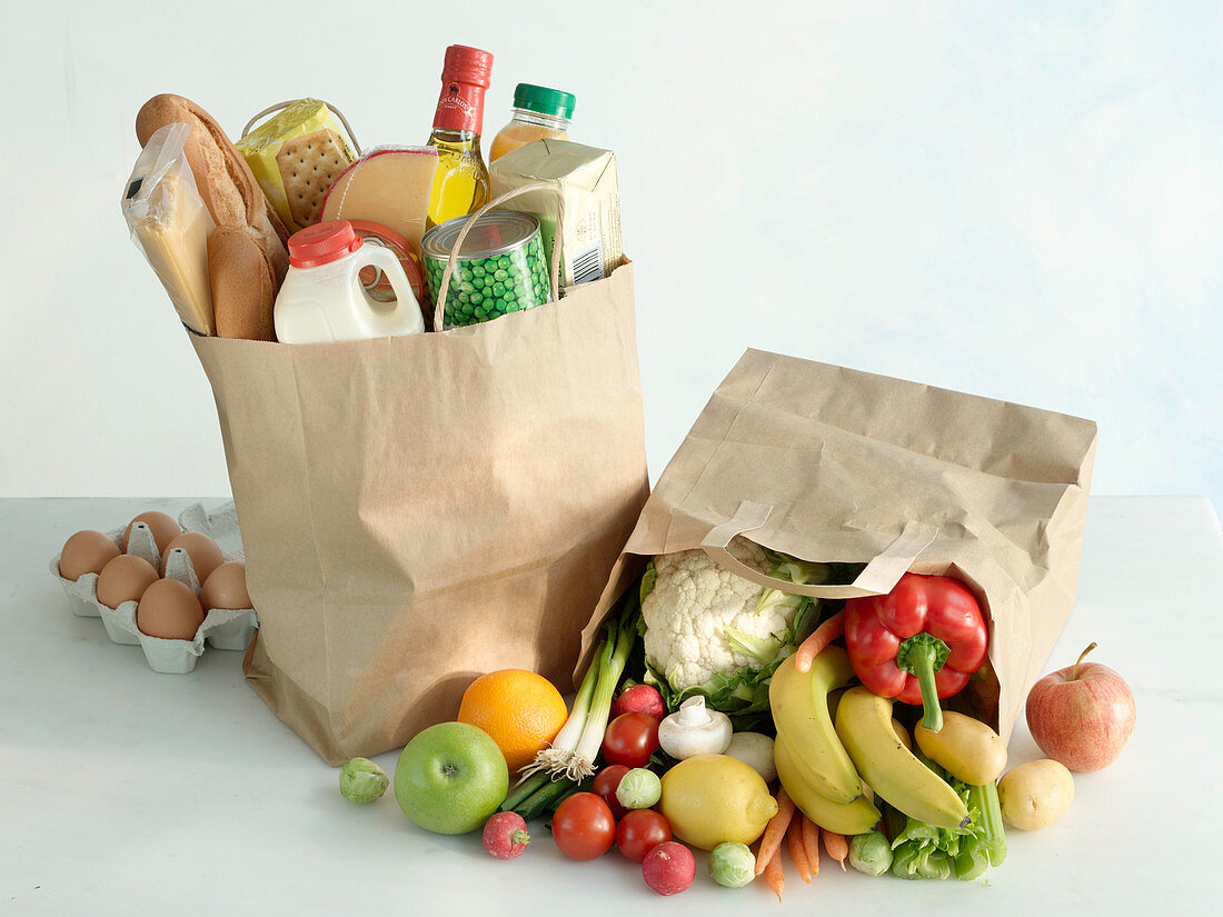 Zwei Einkaufstüten mit verschiedenen Lebensmitteln und mit Obst und Gemüse