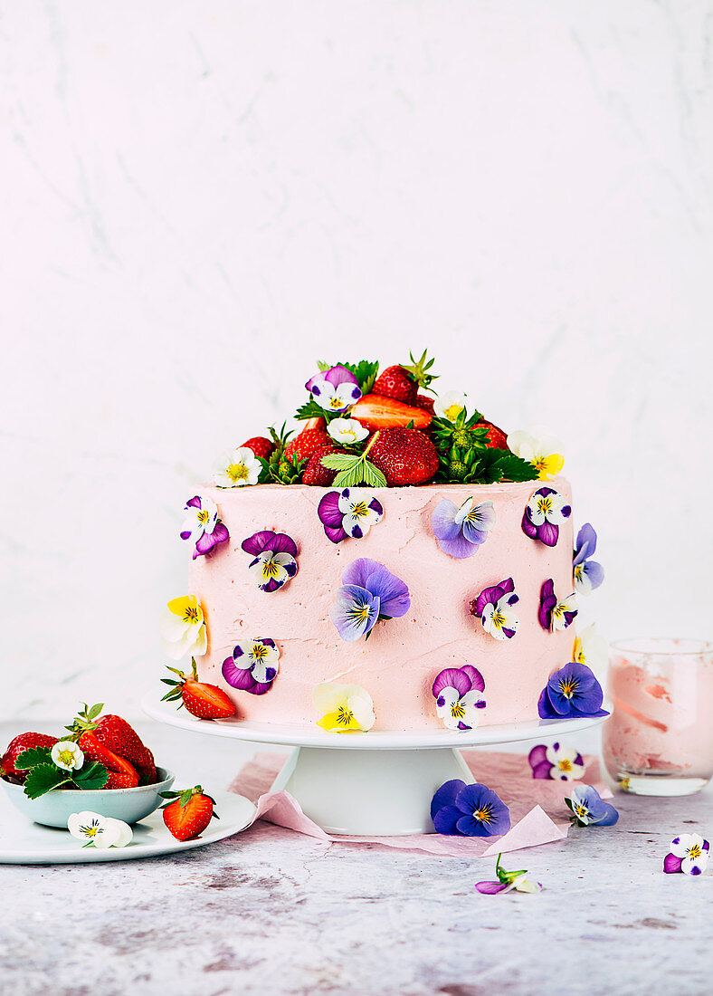 Strawberry buttercream cake decorated with edible flowers