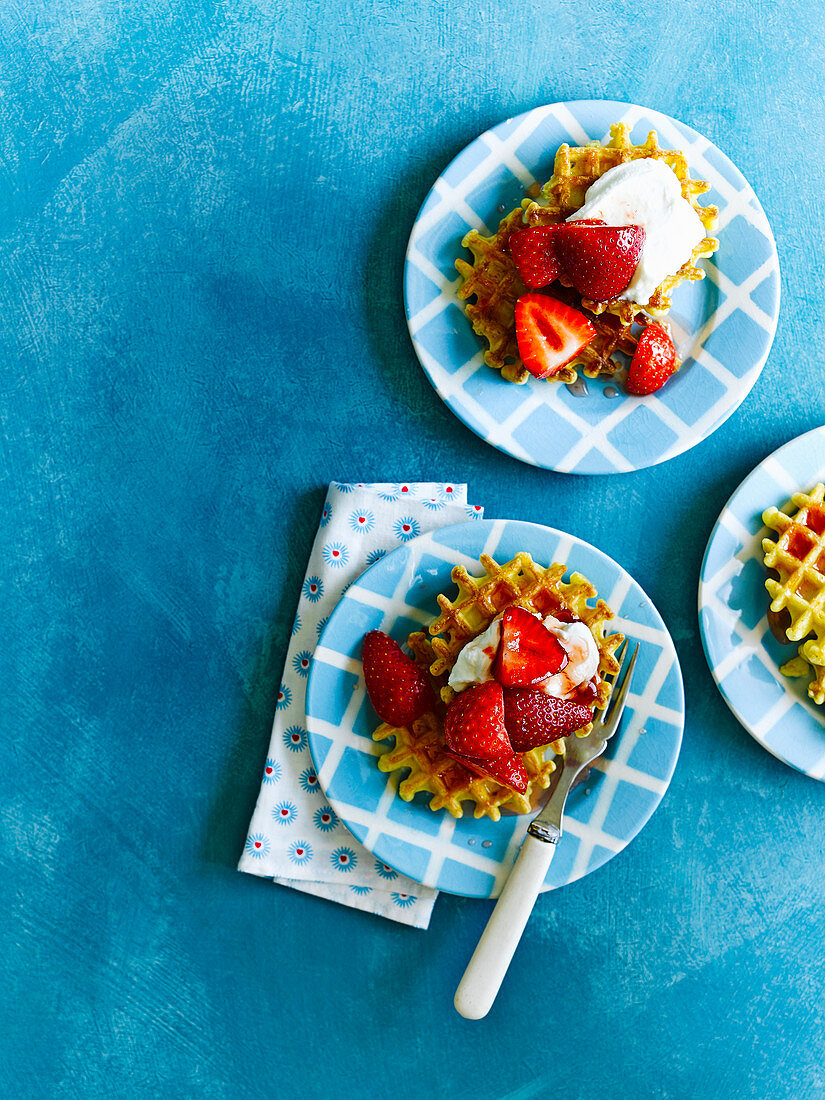 Toasted waffles with strawberries in rose syrup and Greek yogurt