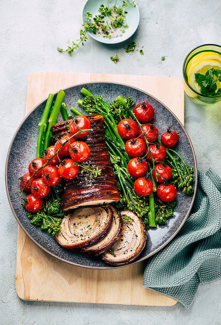 Rolled pork roast with roasted tomatoes and broccolini