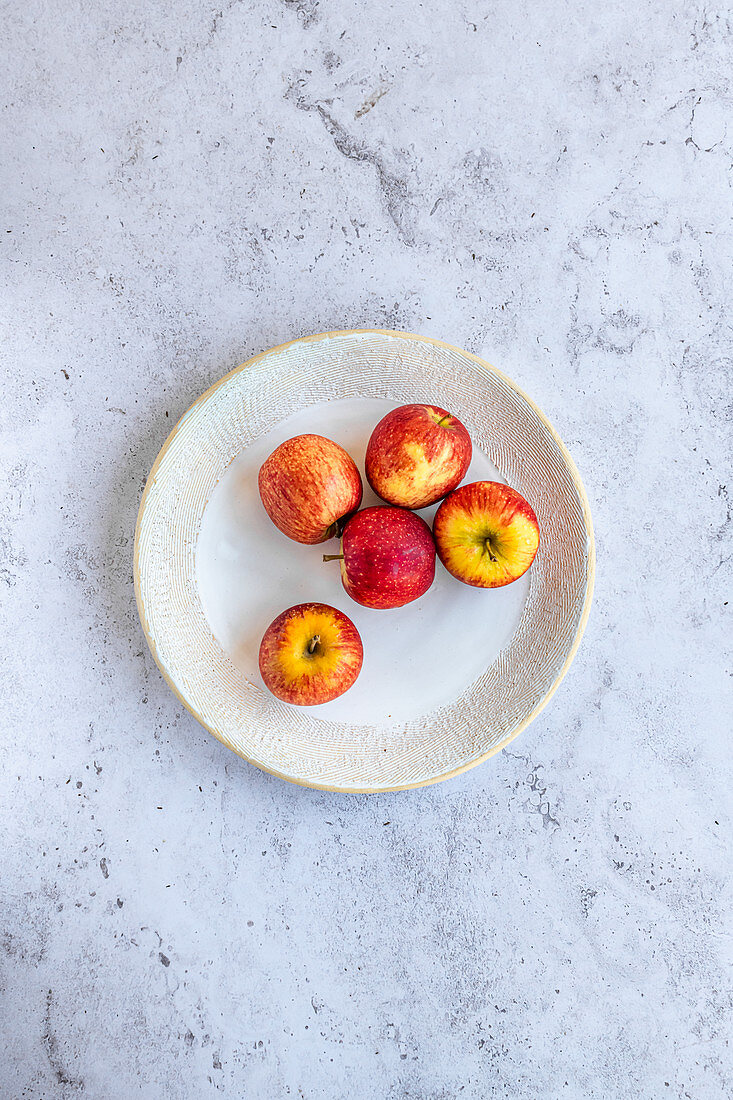 Envy apples on a decorative ceramic plate