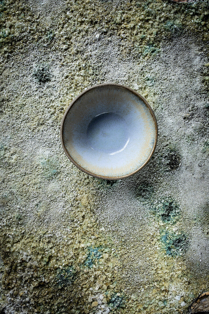 Bowl with patina on a concrete surface