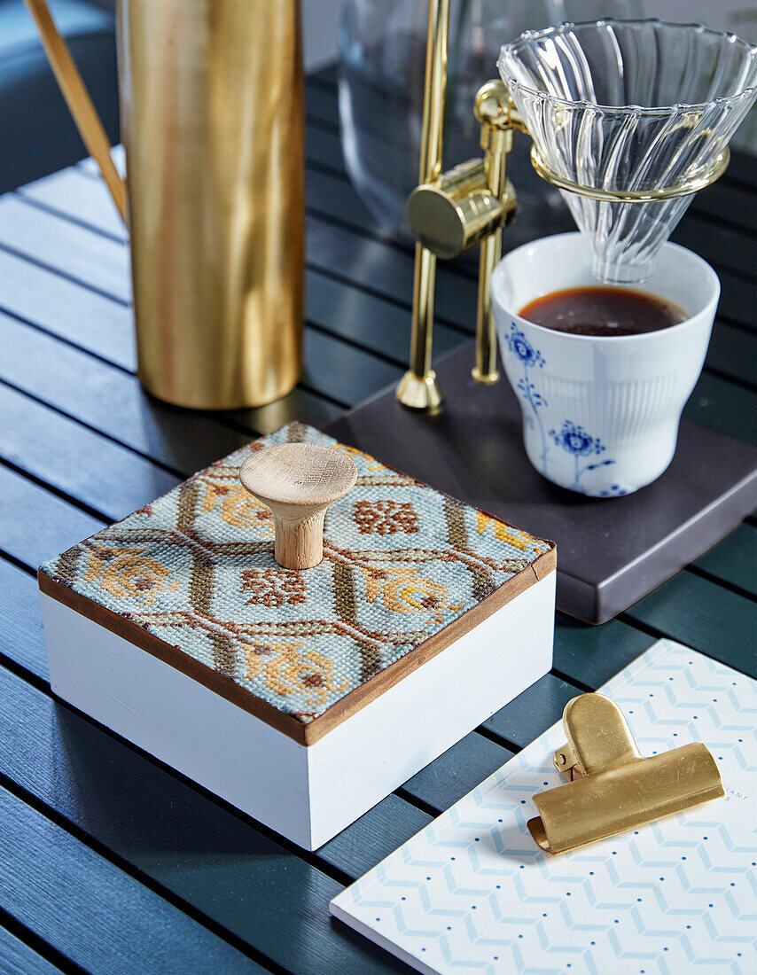 Wooden box with embroidery and a cup of coffee on glass pour over coffee filter