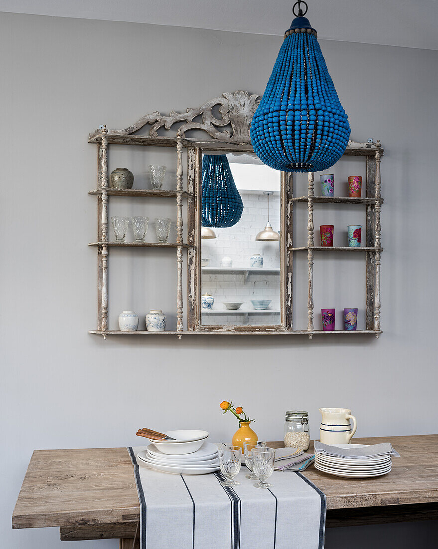 Blue turquoise chandelelier in front of old bistro shelf with mirror panel, provence wine glasses and selvedge napkins