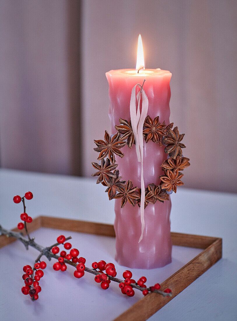 Pink candle decorated with star anise wreath