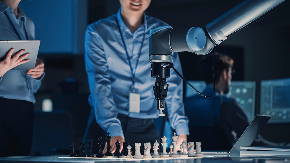 Engineer playing chess against a robotic arm