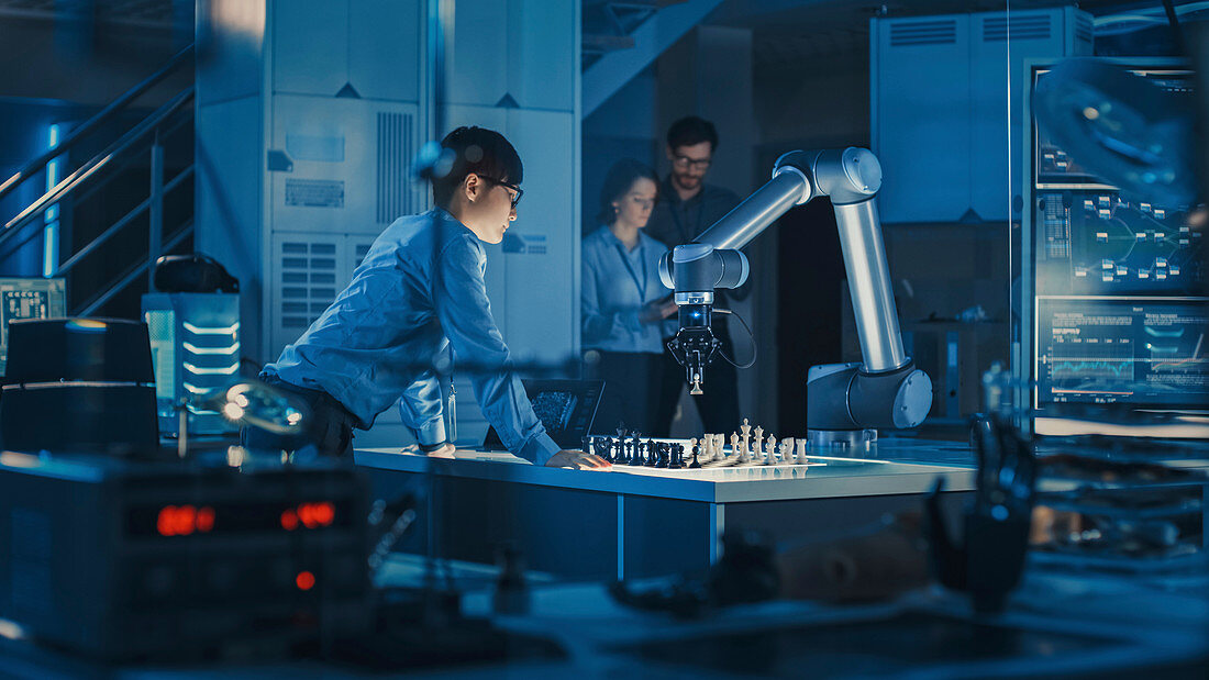 Engineer playing chess with a robotic arm