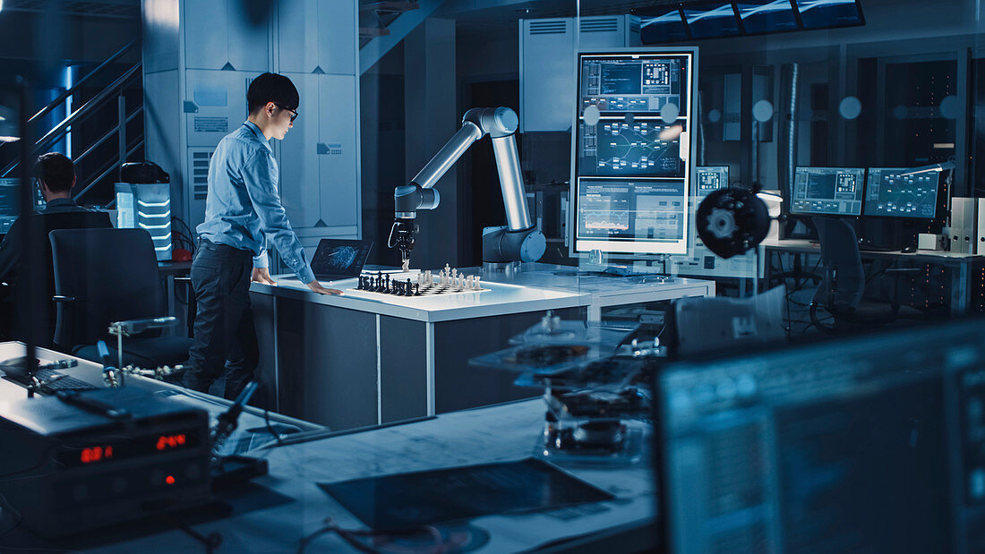 Engineer playing chess with a robotic arm