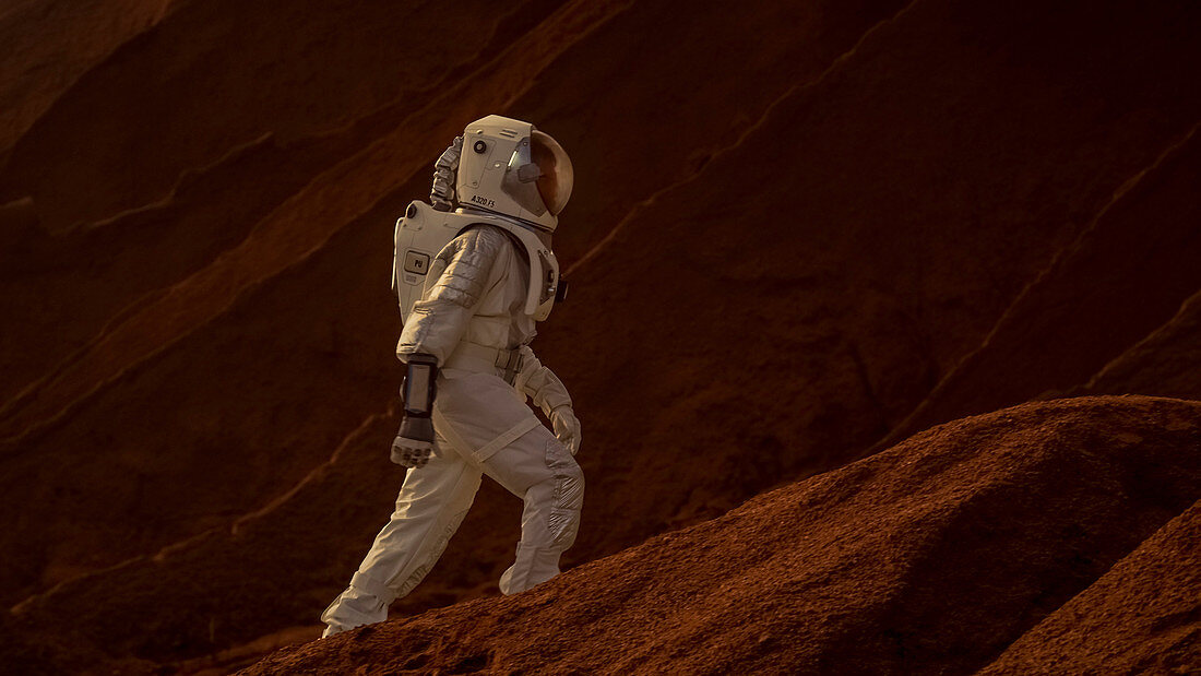 Astronaut going up a mountain to explore a red planet