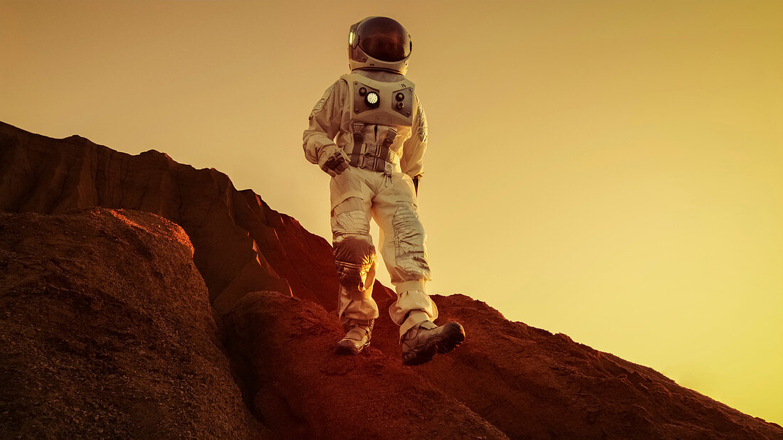 Astronaut descending from a mountain on a red planet
