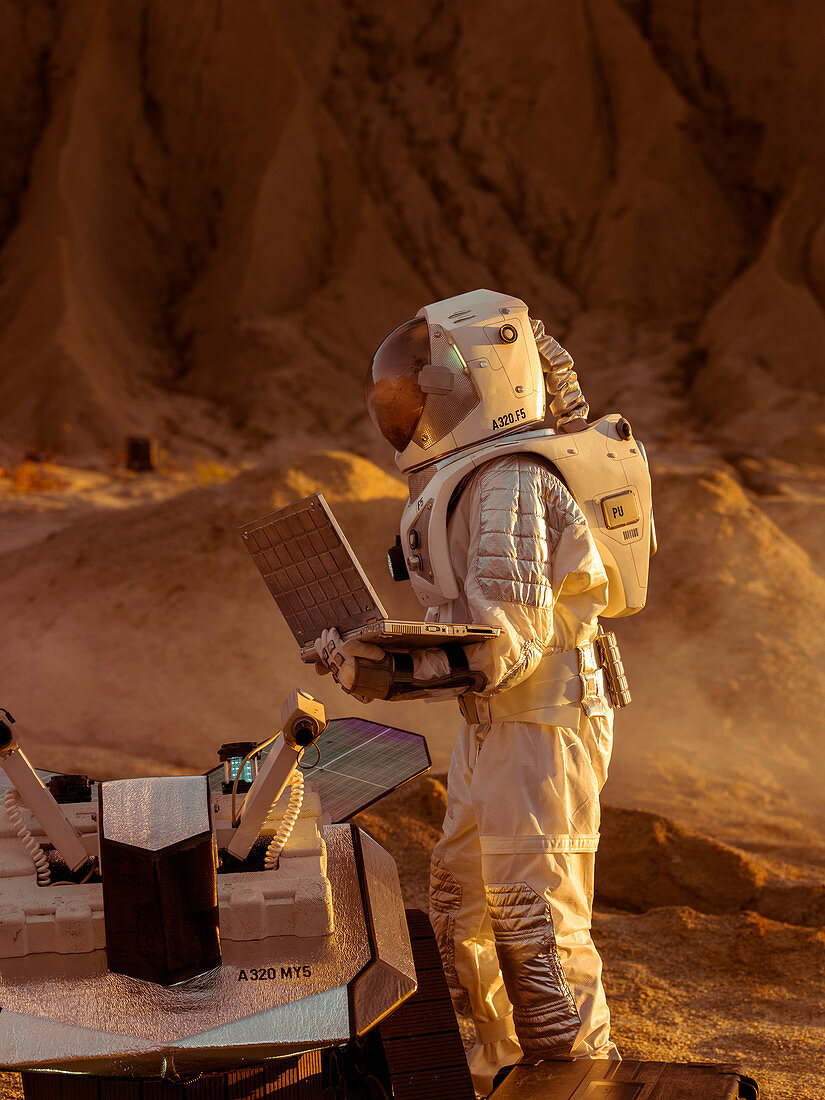 Astronaut using a laptop to adjust a rover for alien planet
