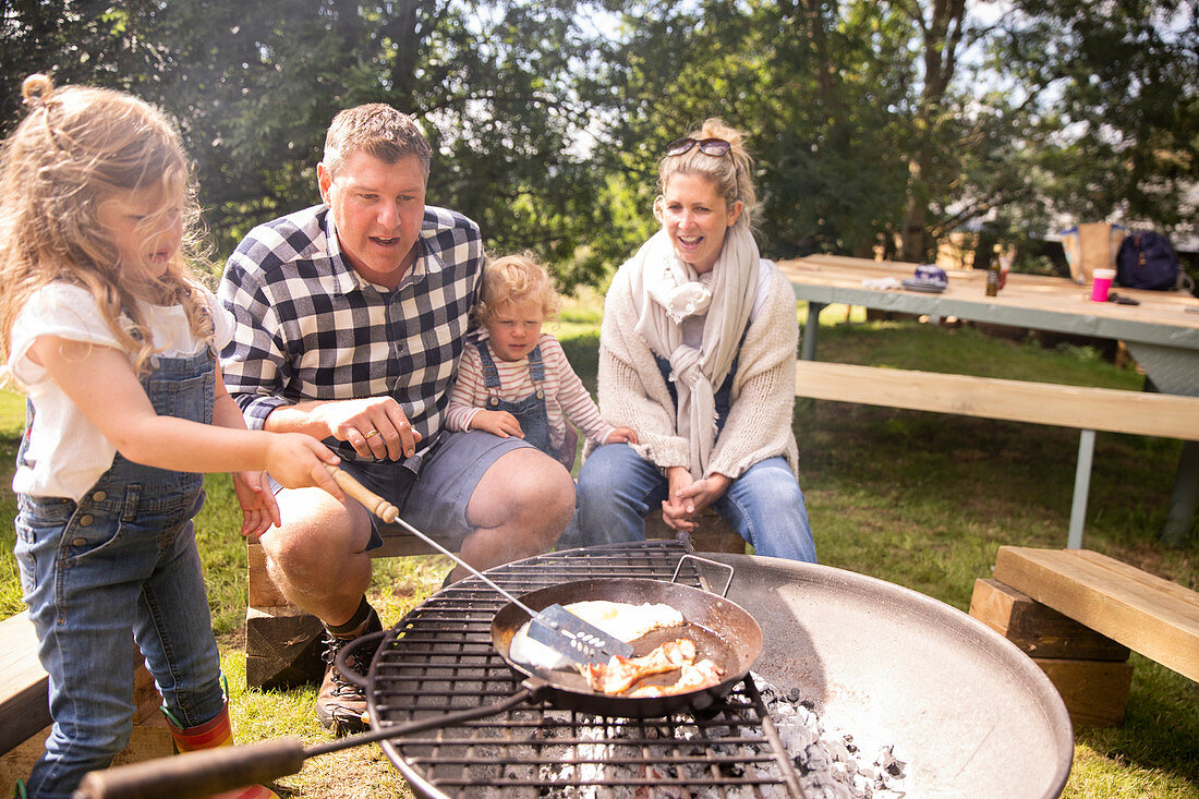 Happy family barbecuing at campsite