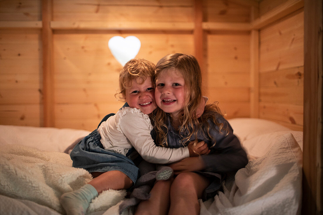 Sisters hugging in bed