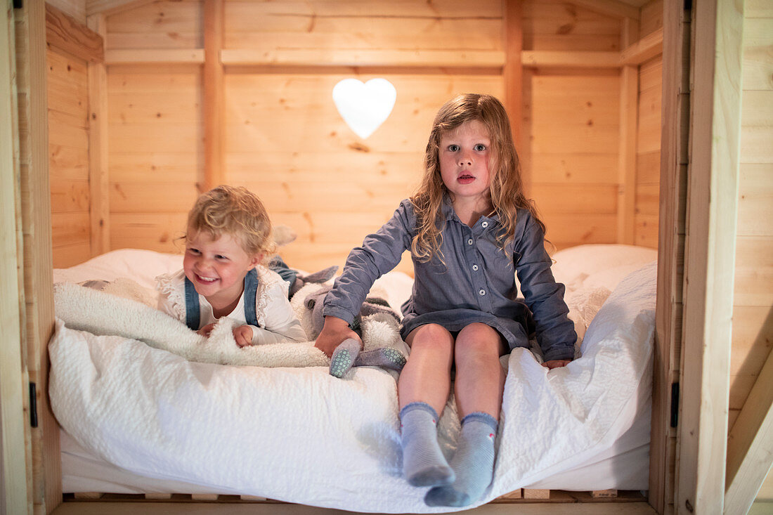 Sisters on bed in cabin