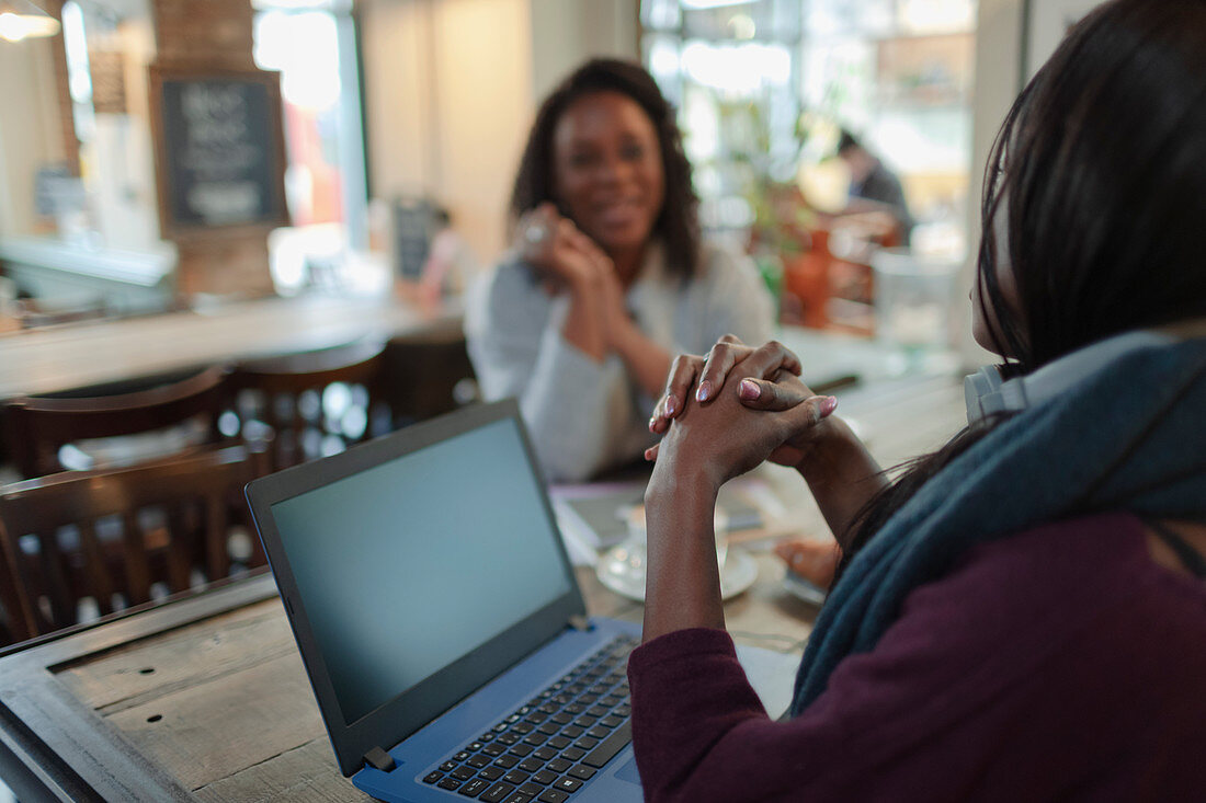 Businesswomen meeting at laptop in cafe