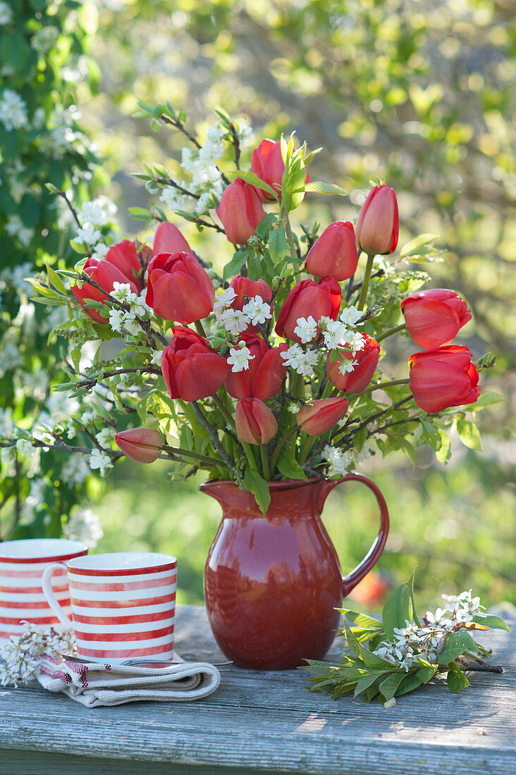 Spring bouquet of red tulips, ornamental cherry, and bird cherry
