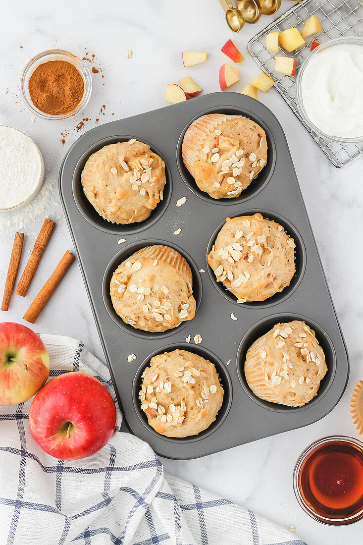 Baked Apple Cinnamon Muffins in muffin tin with ingredients