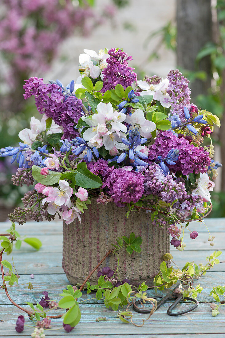 Spring bouquet of lilacs, bluebells, crab apple branches, and chocolate vine