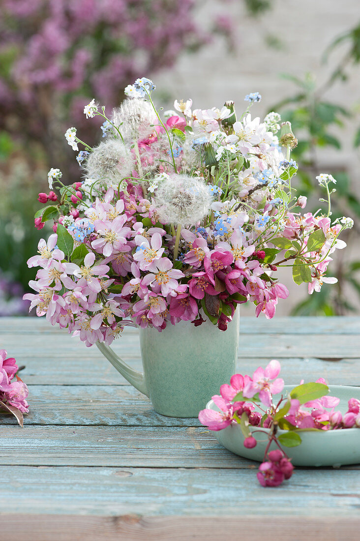 Bouquet of crab apple branches, forget-me-nots, and dandelions