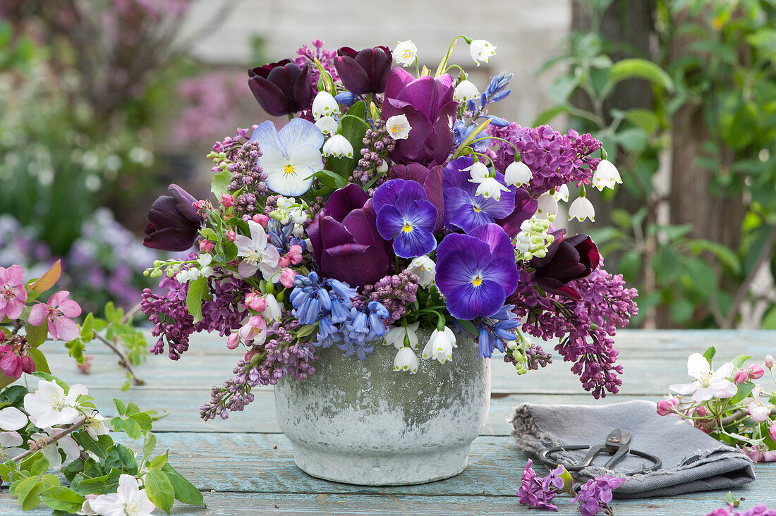 Spring bouquet of lilacs, tulips, bluebells, spring snowflakes, pansies, and crab apple branches