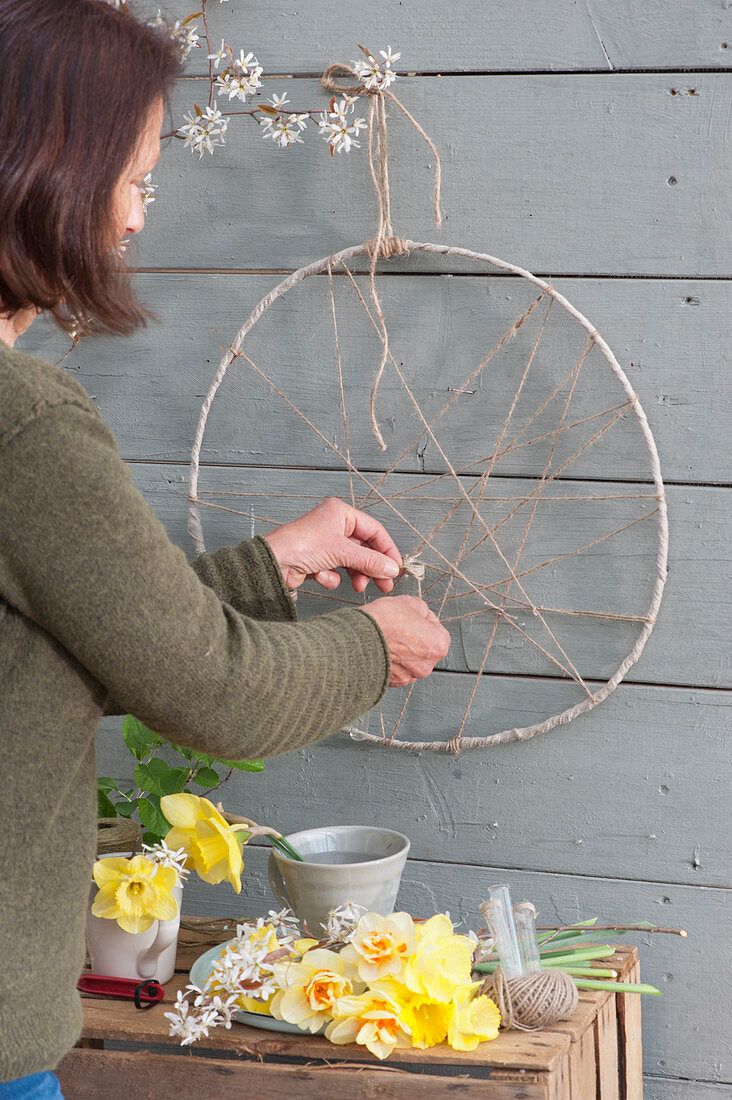 Woman creates hanging Easter decoration on the terrace