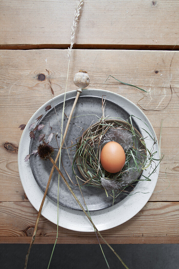 Kleines Osternest mit Trockengräsern und Mohnkapsel