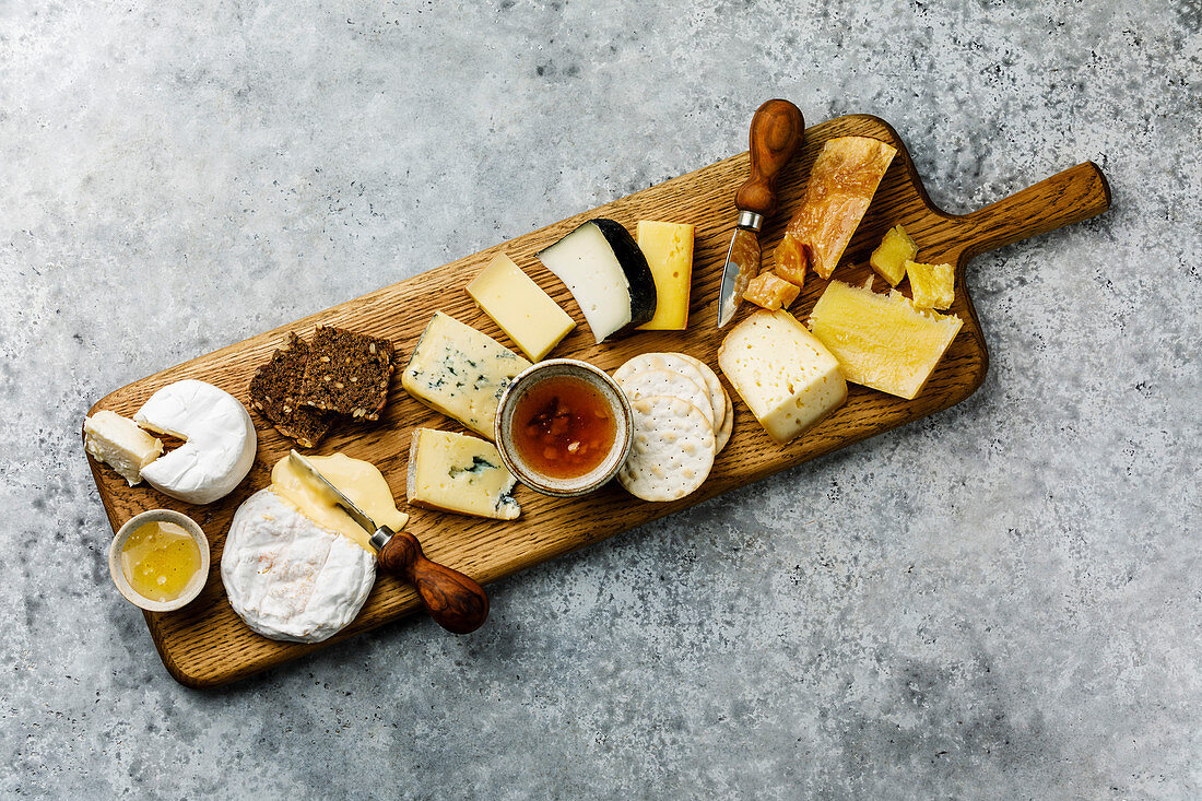Different types of cheese Snack assortment on wood serving cheese board