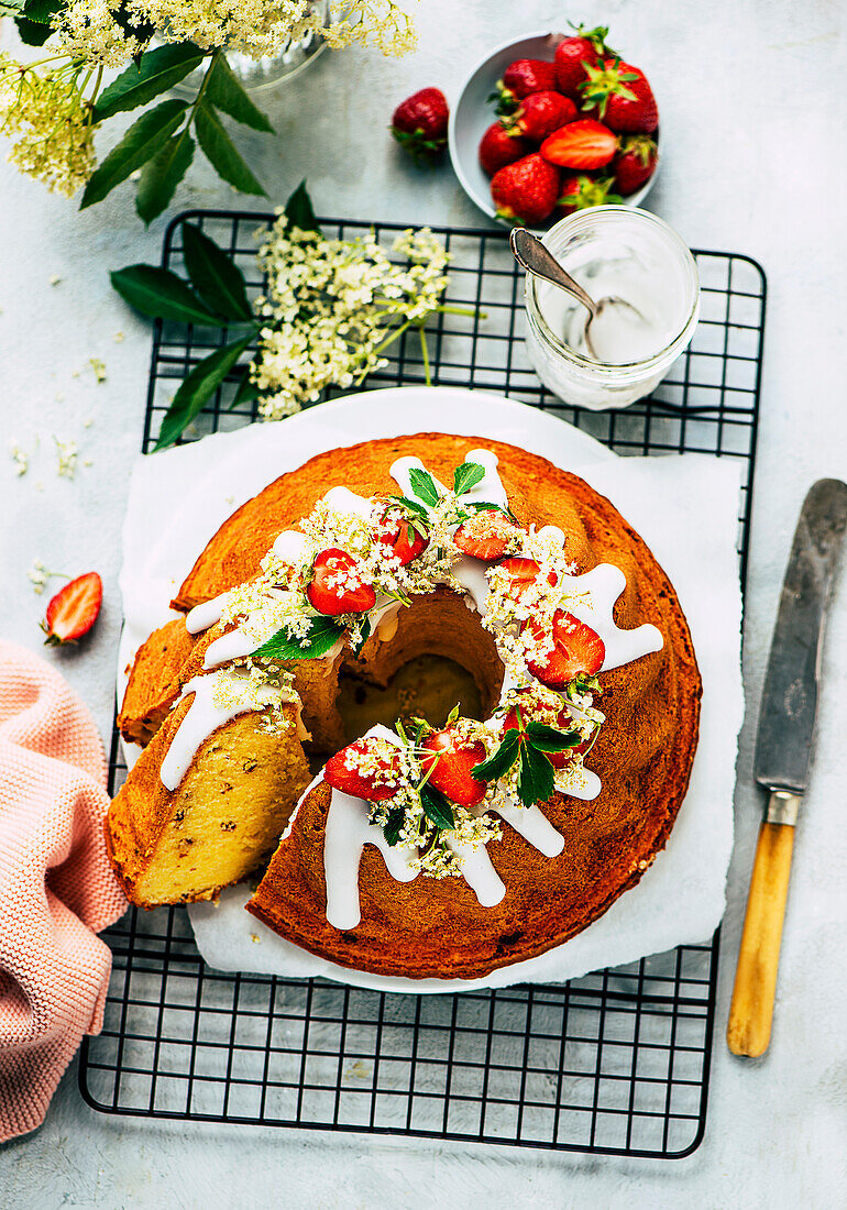 Saftiger Holunderblüten-Guglhupf mit Schokosplittern und Erdbeeren