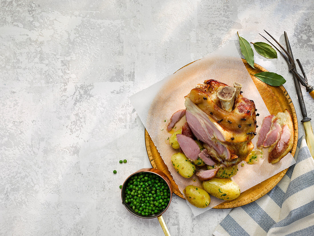 Roast ham peppered with cloves, with parsley potatoes, and peas