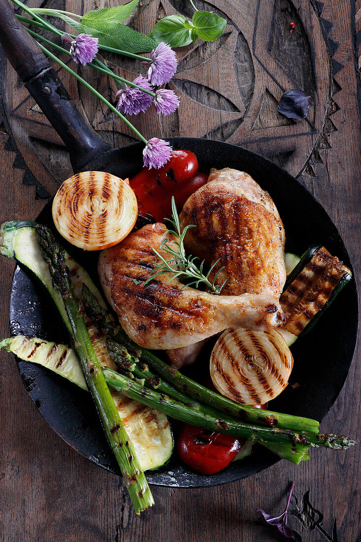 Gegrillte Hähnchenkeullen mit Grillgemüse in der Pfanne