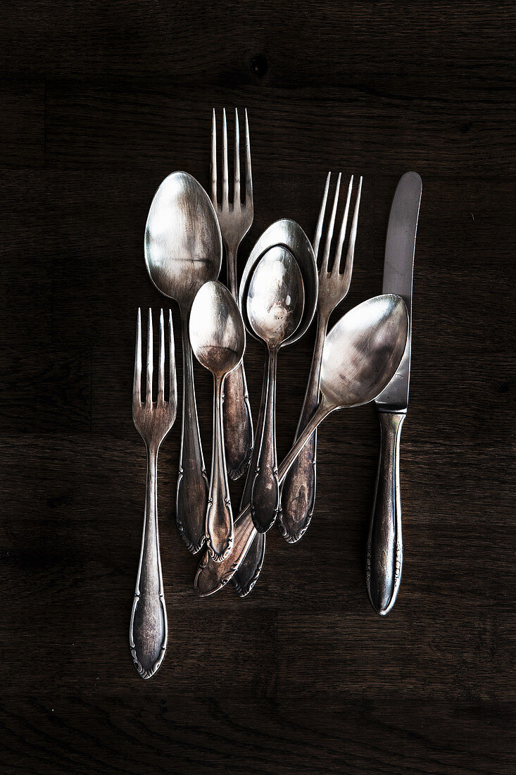 Silver cutlery on a dark wooden background