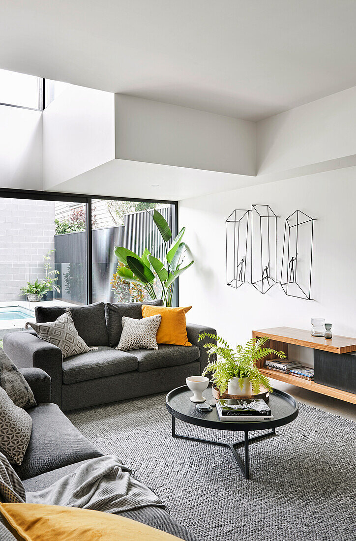 Grey sofa set, coffee table and lowboard in light-flooded seating area