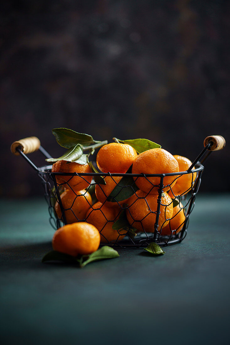 Mandarinen im Korb vor dunklem Hintergrund