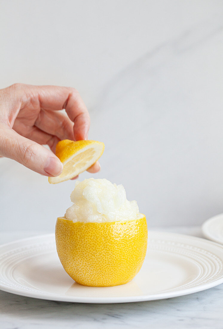 Ausgehöhlte Zitrone gefüllt mit Zitronengranita