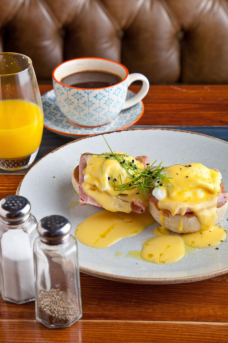 Eggs Benedict breakfast - Two poached eggs on muffins, with ham and hollandaise sauce
